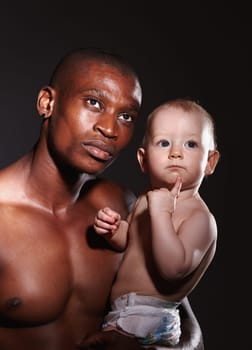 Man, young child and interracial by black background for love, protection and strong bond. Development, baby and male person in studio with adoption for growth, affection together as foster family