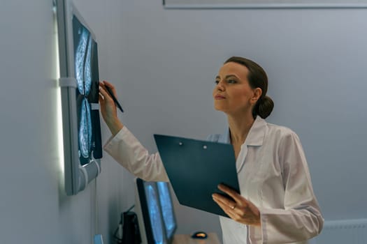 Smiling professional doctor radiologist analyzing scan MRI images in medical center