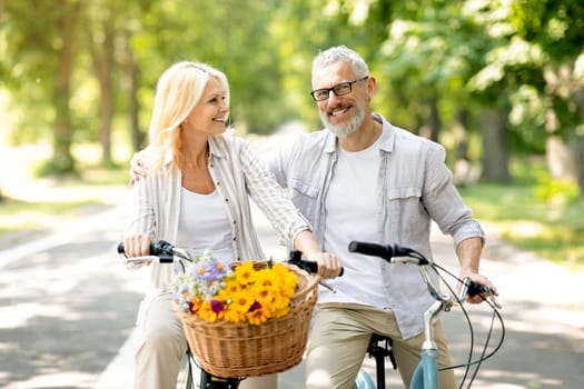Portrait Of Happy Senior Spouses Having A Ride On Bicycles In Park