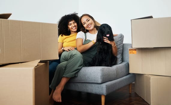 Real estate, portrait and lesbian couple with a dog on the sofa for moving boxes and a new home. Smile, lgbt and women or people on the living room couch of an apartment with a pet after relocation