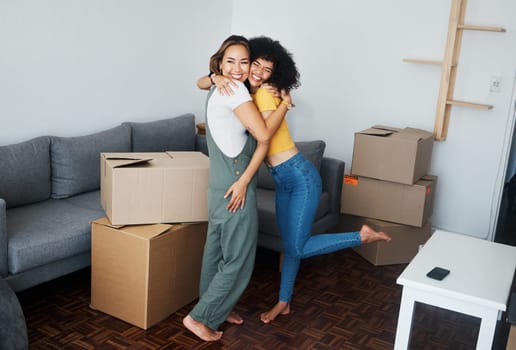 Lesbian, couple and hug with moving, boxes and excited with happiness for investment in apartment or property. Happy, people and women together with love and celebration of new home together
