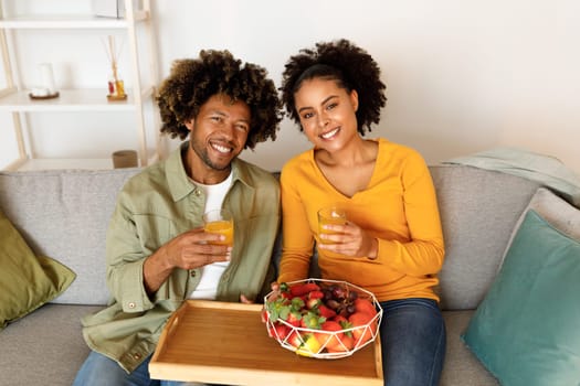African American Young Spouses Holding Glasses Of Orange Juice Indoor
