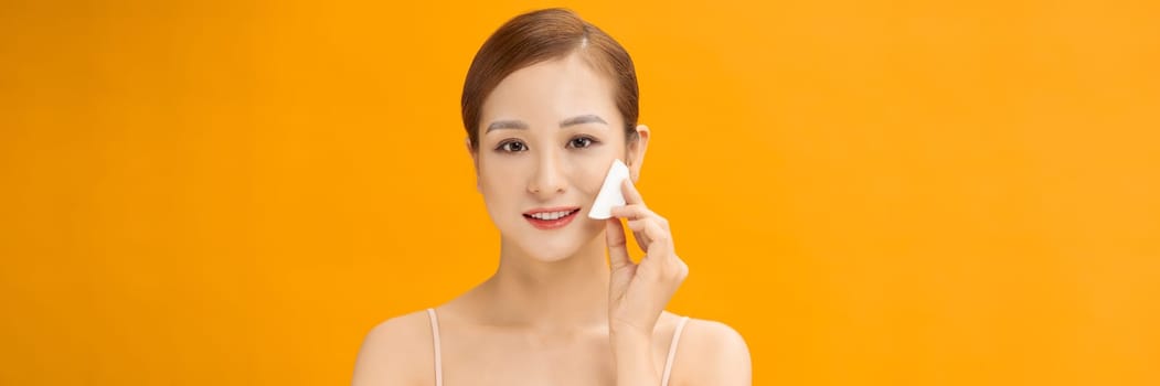 Woman Using Cotton Pad Cleansing Face Over banner yellow Background