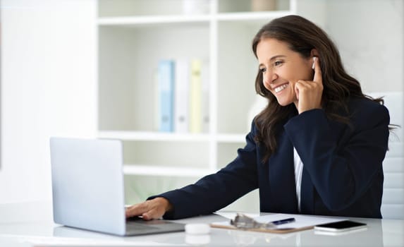 Positive mature woman entrepreneur get video call at office