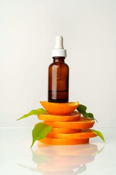 Skincare oil bottle on stacked orange slices