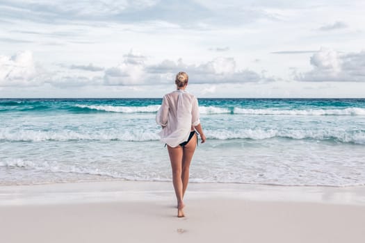 Woman on summer vacations at tropical beach of Mahe Island, Seychelles.