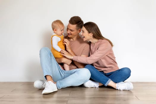 Happy Family Of Three With Infant Baby Having Fun Together At Home