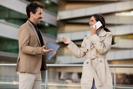 Business colleagues mature man and woman greeting each other