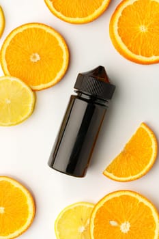 Vape smoking liquid with orange flavor on white background with orange pieces