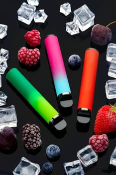 Electronic cigarette with berries and ice cubes on black background