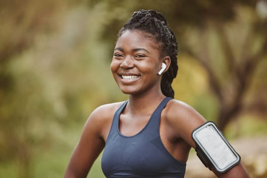 Fitness, smile and portrait of black woman at outdoor exercise, workout or training in a forest for wellness. Happy, confident and young person ready and listening to music, audio or podcast