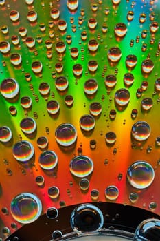 Abstract background asset metallic surface of rainbow colors with water droplets