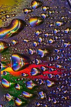Burst of fizzy soda bubbles with metallic surface and rainbow colors in dark background asset