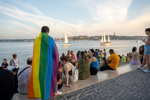Lisbon, Portugal. 17 June 2023 Man wearing gay pride flag at gay pride parade