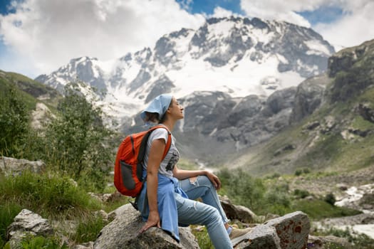 A woman with backpack in the mountains