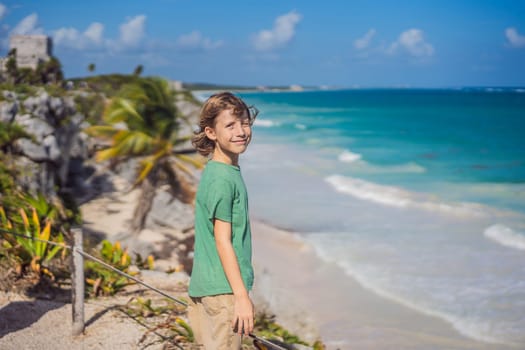 Boy tourist enjoying the view Pre-Columbian Mayan walled city of Tulum, Quintana Roo, Mexico, North America, Tulum, Mexico. El Castillo - castle the Mayan city of Tulum main temple