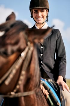 Portrait, equestrian and a woman with an animal on a ranch for sports, training or a leisure hobby. Horse riding, smile or competition and a happy young rider in uniform with her stallion outdoor