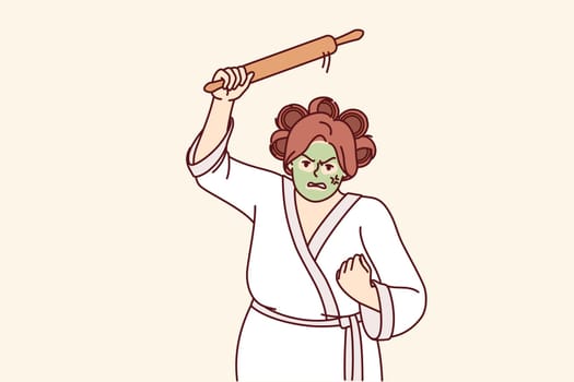 Aggressive woman holding rolling pin and threatening to be beaten, dressed in bathrobe with curlers