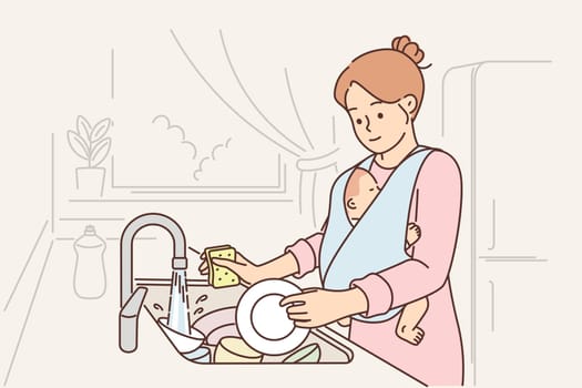 Caring mother washes dishes and holds baby, needing husband help to do housework