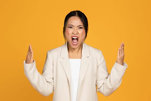 Angry excited crazy sad young asian woman in suit screaming, freaking out