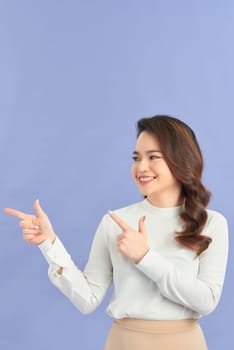 young excited woman point finger showing something to side empty copy space
