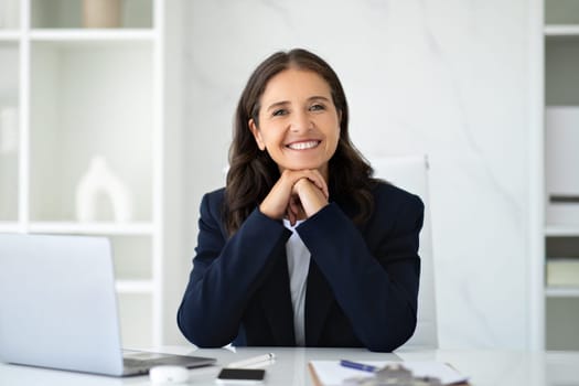 Attractive middle aged businesswoman posing at office