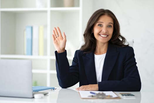 Friendly mature woman counselor greeting client at office