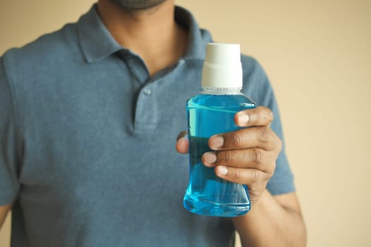 hand hold a mouthwash liquid container