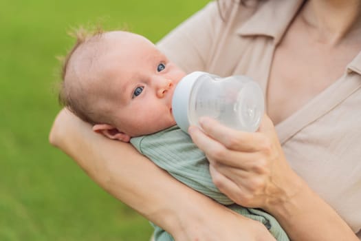 Mother giving to drink water baby from bottle, closeup