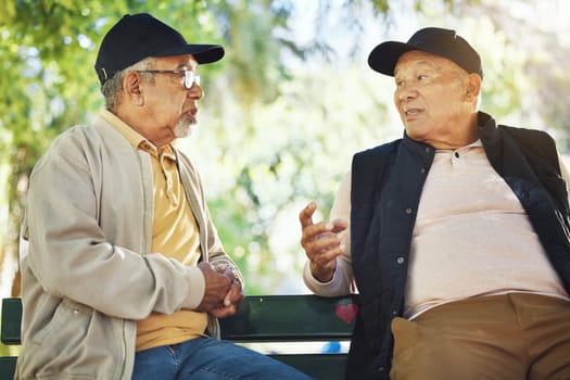 Elderly men, park and communication with friendship, nature and conversation with bonding on bench. Diversity, closeup and old people with community for socialize, relaxation and discussion on life