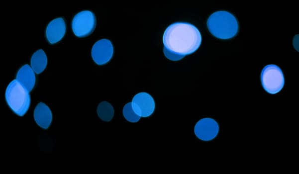 Blue, lights and bokeh in a studio with dark background for celebration, event or party. Confetti, glitter and color sparkles for magic, shine or glow for festive by black backdrop with mockup.