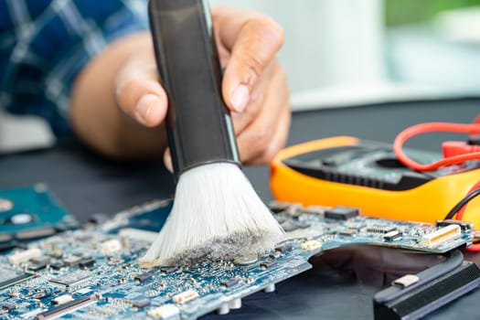 Asian technician repair and cleaning dirty micro circuit main board of smartphone electronic technology with brush, hardware, mobile phone, upgrade concept.