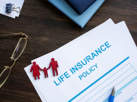 Life insurance policy and figurines of family.