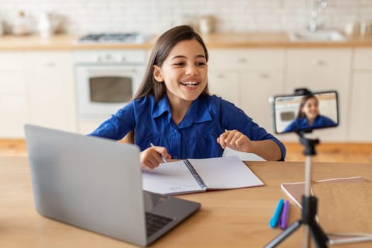 Cheerful Arab Schoolgirl Having Online Lesson Via Cellphone At Home