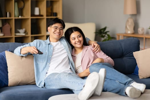 Happy Korean Couple Watching Movies On TV Relaxing At Home