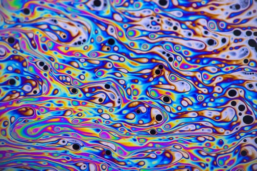 Macro photo of colourful pastel swirly patterns of a soap bubble