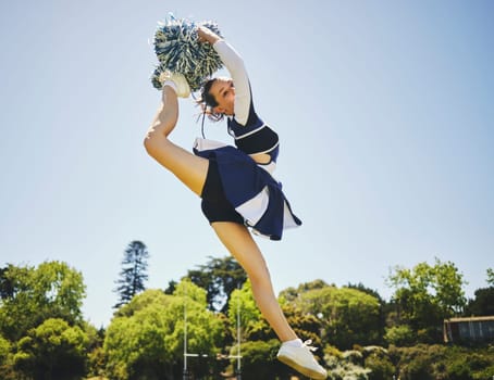 Fitness, jump and woman cheerleader on a field for motivation or support practice with team. Sports, cheerleading and female athlete training for skill and dance with energy at competition or match.
