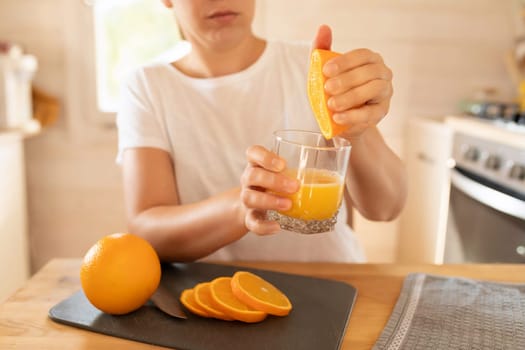 women's hands squeezing juice out of orange slices