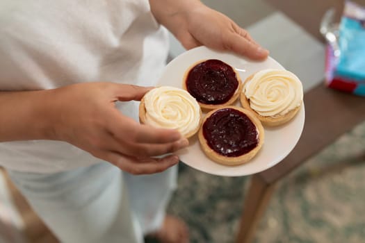 four tartlets on a plate with berry and cream cheese flavors