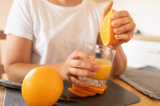 a woman prepares an orange for juicing