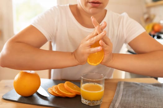 a woman's hands squeeze an orange for juice