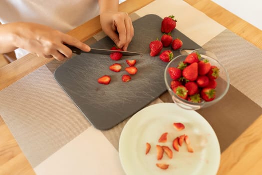 women's hands slicing berries for dessert