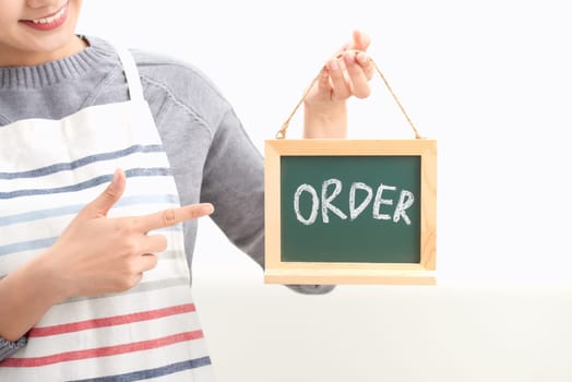 Portrait of waitress showing chalkboard with order sign on white