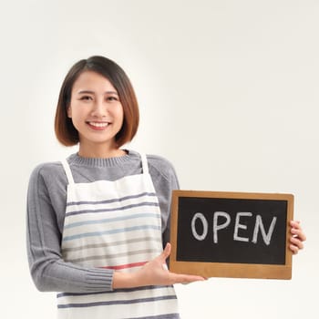 Female business owner holding OPEN sign on white
