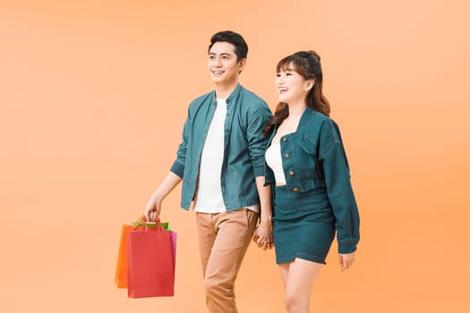 Asian models in love, holiday sales, shop, retail, consumer concept, isolated on color background.