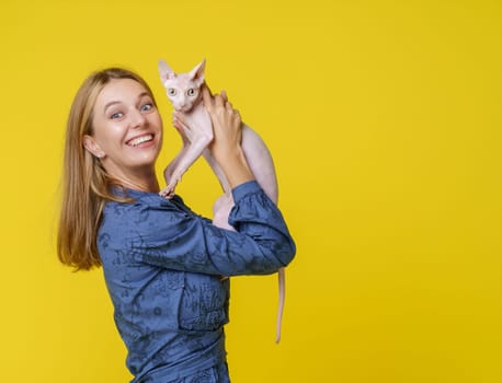 Woman shares heartwarming moment with beloved cat and kisses it affectionately and holds it in hands. Deep bond and love between pet owner and feline companion, reflecting joyful and cherished connection.