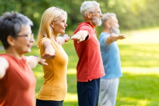 Fitness Training. Group Of Sporty Senior People Exercising Together Outdoors, Happy Older Men And Women Standing In A Row, Spreading Hands And Smiling, Enjoying Active Lifestyle On Retirement