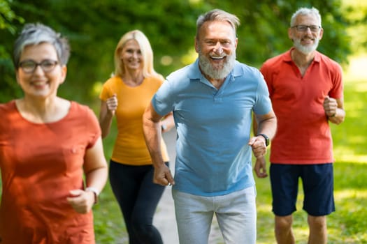 Active Retirement. Group Of Sporty Seniors Jogging Outdoors