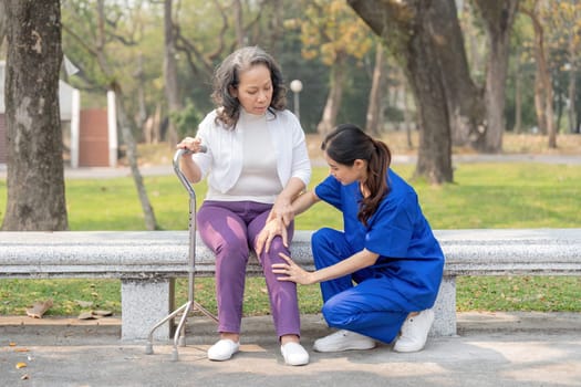 A female nurse or caregiver check the knee the elderly caring the hospital park