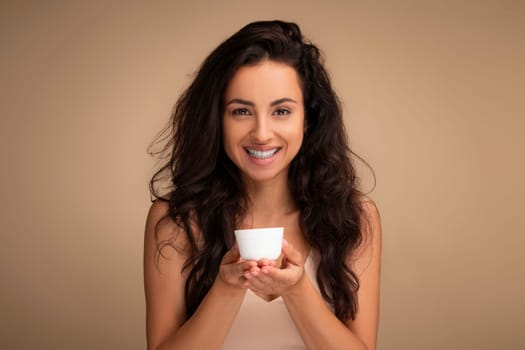Organic cosmetic. Smiling woman holding jar of cream on palms